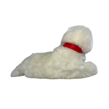 a realistic fluffy white plush dog toy in a lying position