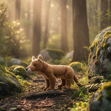 Stuffed animal resembling a Tasmanian Tiger in a forest with sunlight filtering through the trees.