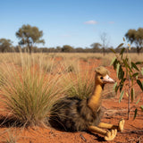 emu in a natural savanna setting with grass and trees.