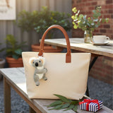 Mini koala plush keychain on tote bag.