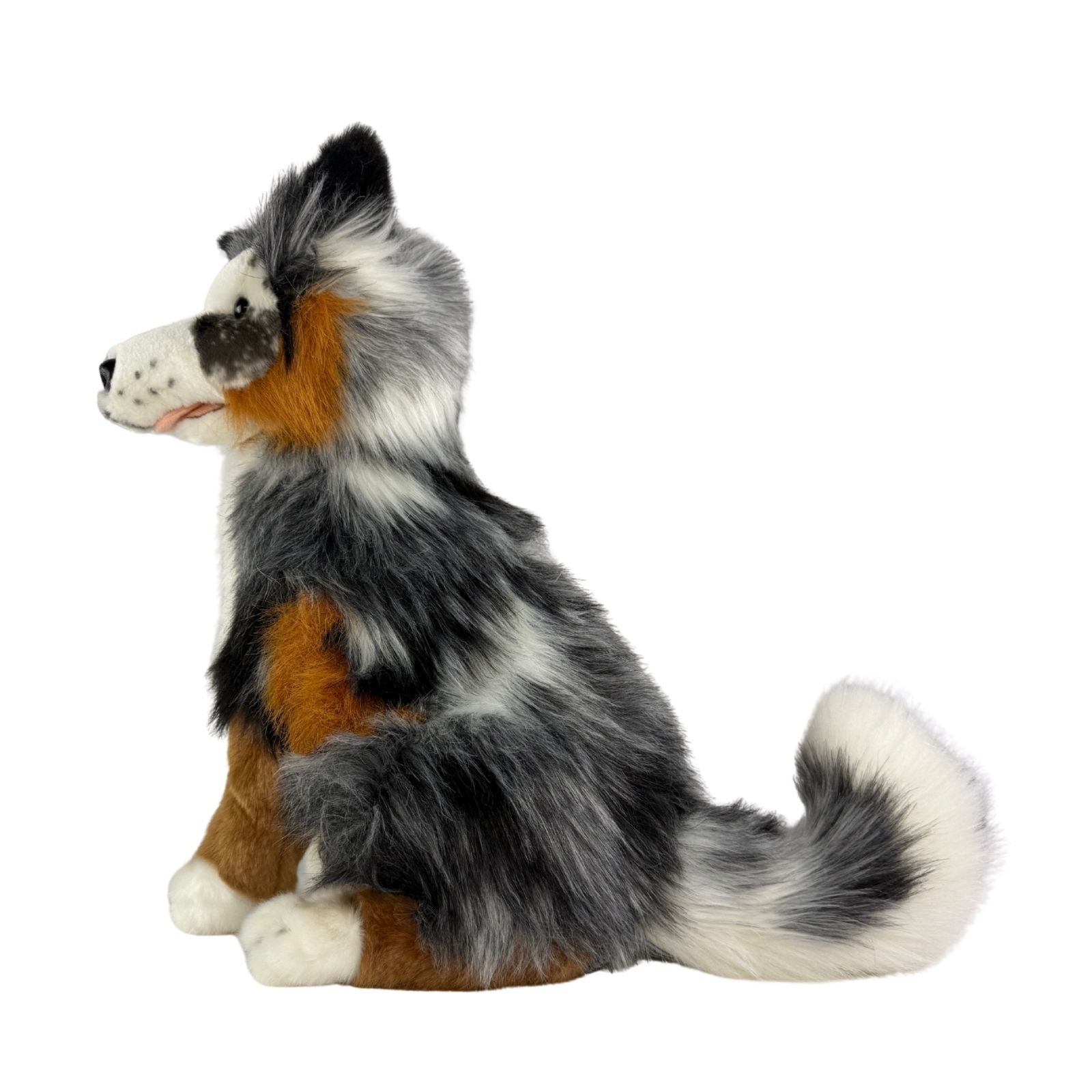 Plush toy dog with black, brown, and white fur on a white background