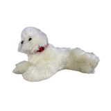a realistic fluffy white plush dog toy in a lying position