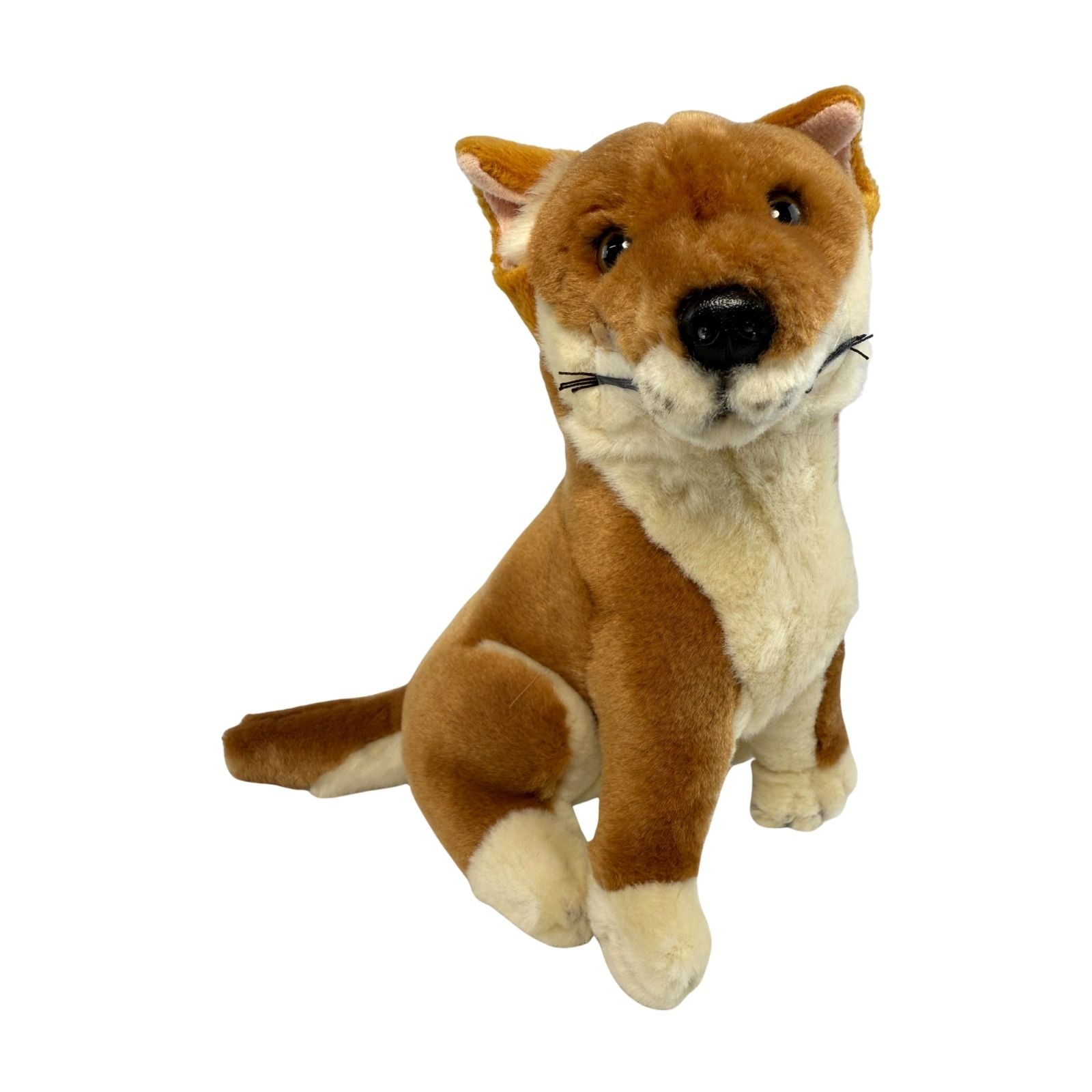 A brown realistic soft plush toy black and tan dingo in a sitting position
