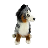Plush toy resembling a dog with black, white, and brown fur on a white background