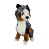 Plush toy resembling a dog with black, white, and brown fur on a white background