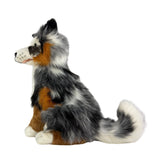 Plush toy dog with black, brown, and white fur on a white background