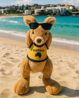 Plush kangaroo wearing sunglasses and an 'Australia' shirt on a beach