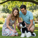 Couple petting Tommy Border Collie plush toy in garden