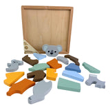 Unassembled wooden koala puzzle with colorful pieces scattered around empty frame