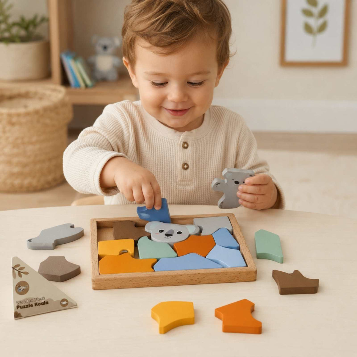 Toddler playing with colorful wooden koala block puzzle at table
